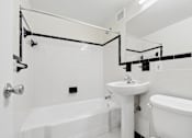 Thumbnail 35 of 59 - A white bathroom with a tub, sink, and mirror.