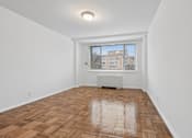 Thumbnail 19 of 59 - A room with wooden flooring and a window overlooking a building.