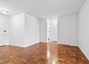 Thumbnail 25 of 59 - One bedroom living space with wooden flooring and white walls.