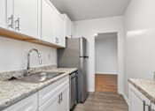 Thumbnail 36 of 59 - A kitchen with white cabinets and a marble countertop.