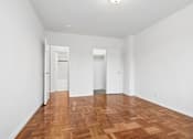 Thumbnail 28 of 59 - A room with wooden floors and white walls.