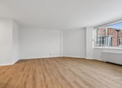 Thumbnail 39 of 59 - A room with wooden flooring and white walls.