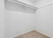 Thumbnail 33 of 59 - A white wall with a shelf above a carpeted floor.