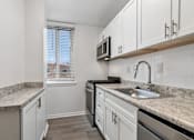 Thumbnail 38 of 59 - A kitchen with white cabinets and a granite countertop.