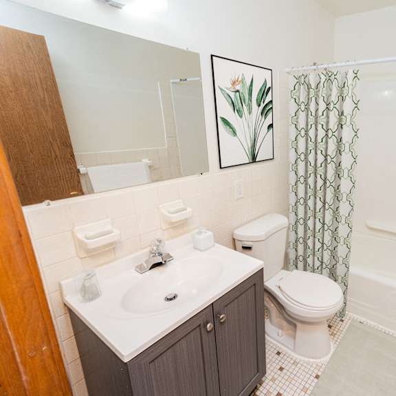 A bathroom with a toilet, sink, and shower.