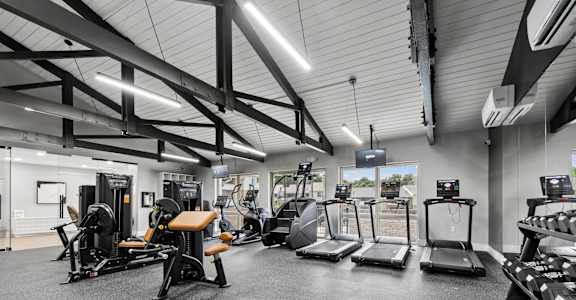 A gym with treadmills, weights, and exercise equipment.