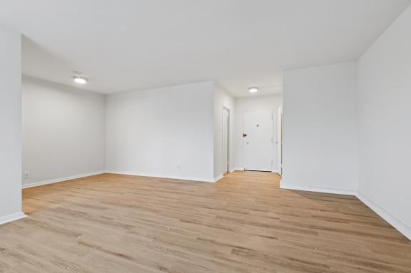 A room with wooden flooring and white walls.