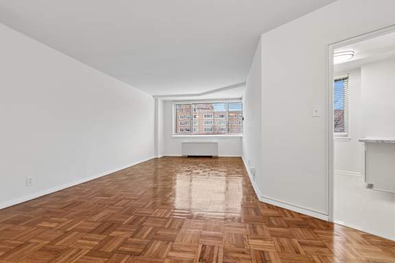 One bedroom living area wooden flooring and white walls.