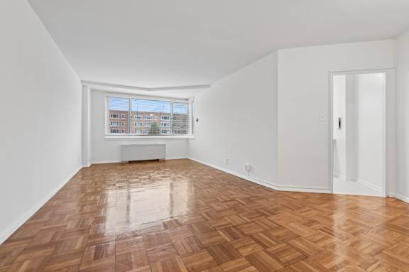 A room with wooden flooring and white walls.