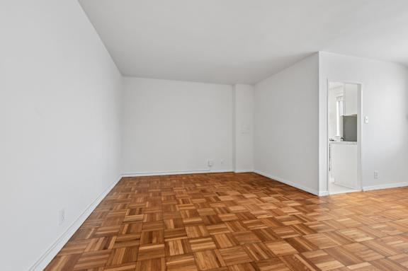 A room with a wooden floor and white walls.