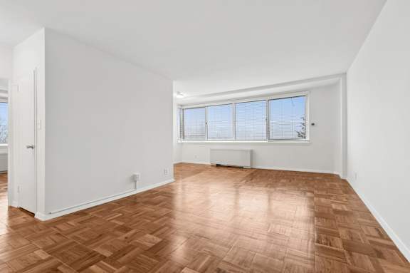 A room with a wooden floor and a window.