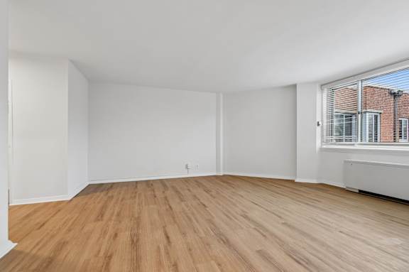 A room with wooden flooring and white walls.