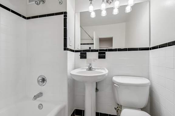 A white bathroom with a sink, toilet, and bathtub.