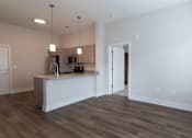 Thumbnail 6 of 8 - A kitchen with a white counter and a white door.