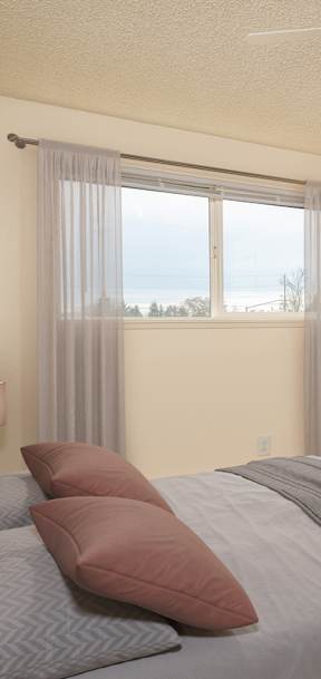 A bedroom with a large bed and a ceiling fan.