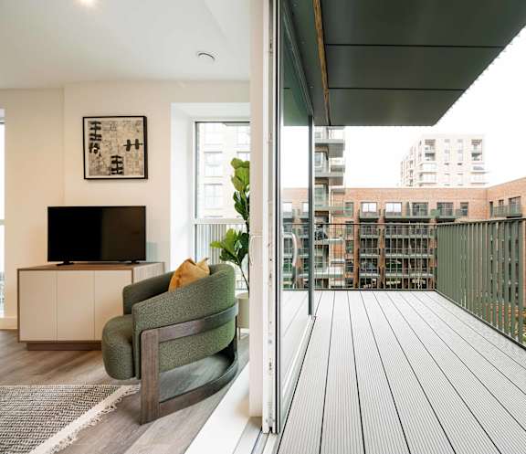 A modern office lobby with a reception desk and a green armchair.