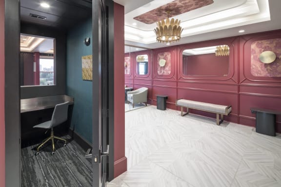 a conference room with red walls and white flooring and a gold chandelier