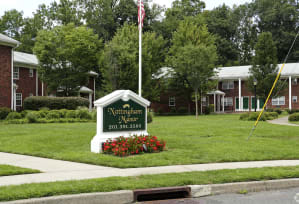 a flagpole with an american flag in front of a building at Nottingham Manor Apartments, Montvale, New Jersey