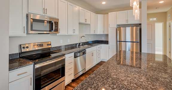 A kitchen with granite countertops and stainless steel appliances.