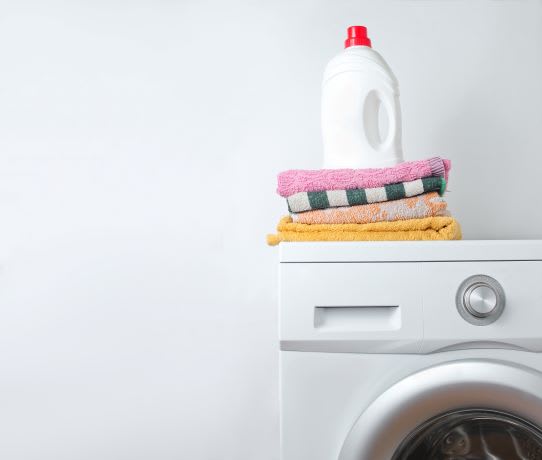 A stack of towels and a bottle of detergent on top of a washing machine at Countryside River Apartments, Wilmington, IL, 60402