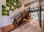 Thumbnail 7 of 28 - a staircase in a building with plants on the wall
