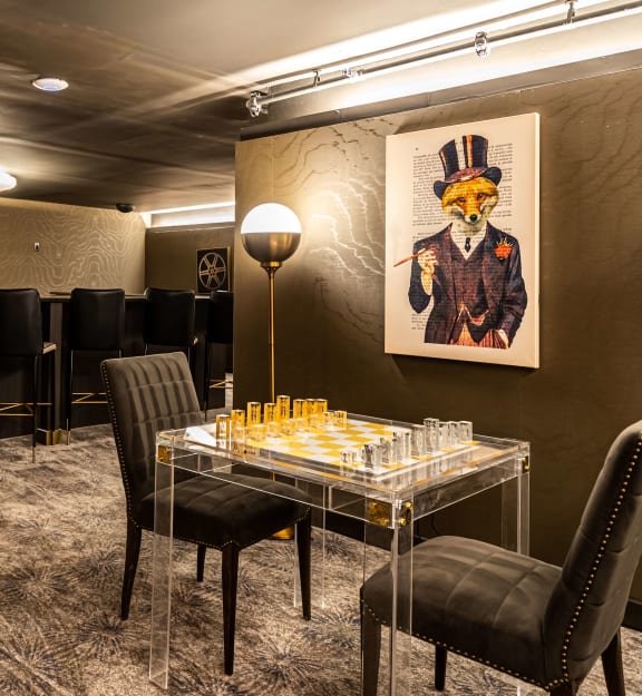 a dining room with a table and chairs and a painting on the wall  at The Grand, Kansas City, 64106
