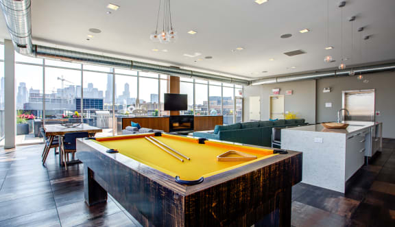 a pool table in a party room with a view of the city