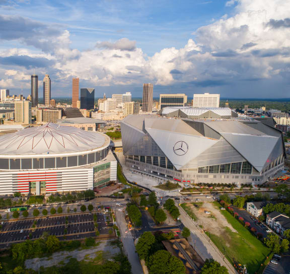 arial view of the mercedes benz stadium with the atlanta skyline in the background