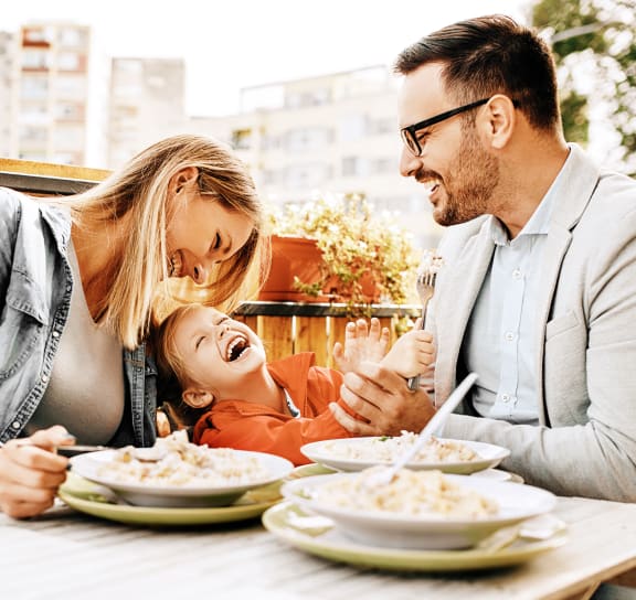 a man and woman sitting at a table with a child