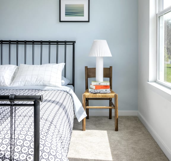 a bedroom with a bed and a table with a lamp