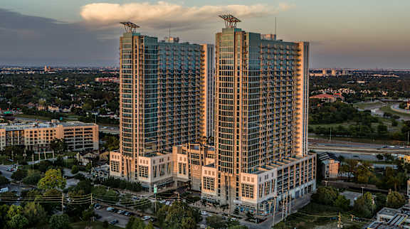 A skyline featuring two towering luxury apartment buildings in Houston, TX
