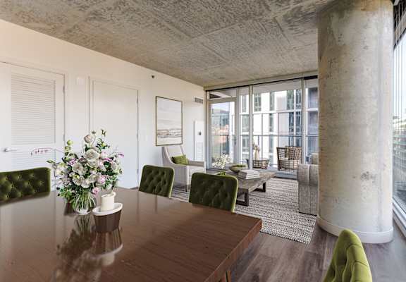 A dining room with a wooden table and green chairs.