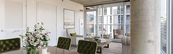 A dining room with a wooden table and green chairs.