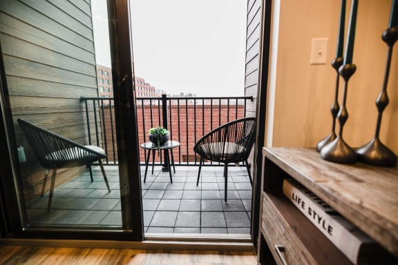 a balcony with two chairs and a table