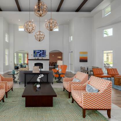 A living room with orange and white patterned chairs and a fireplace.