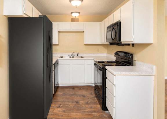 a kitchen with white cabinets and a granite counter top