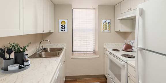 A kitchen with white appliances and brown cabinets.