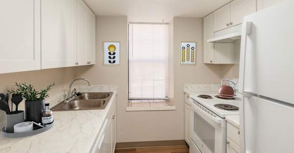 A kitchen with white appliances and cabinets.