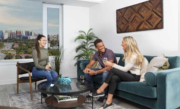 three people sitting on a couch in a living room