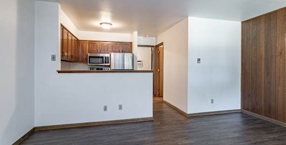 A kitchen with wooden cabinets and a microwave.