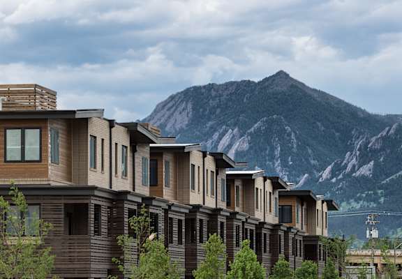 A row of houses with a mountain in the background.