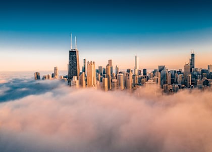 a city skyline covered in fog and skyscrapers