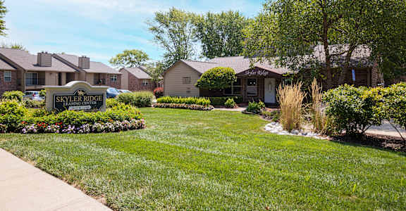 The Skyler Ridge Apartment  clubhouse, featuring a cozy front porch and lush greenery.