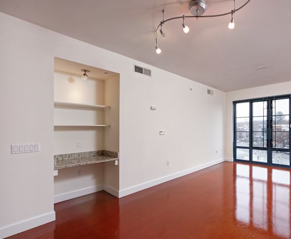 A large empty room with a brown floor and white walls. at Park Place at Petworth, Washington, Washington
