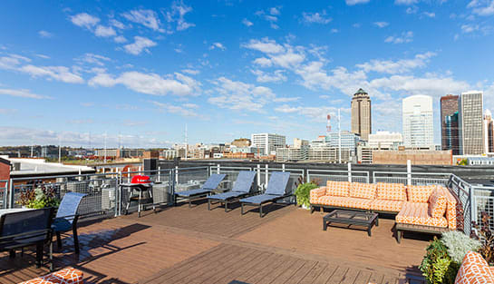 a roof deck with lounge chairs and a fire pit overlooking the minneapolis skyline  at Rocket Transfer Lofts, Des Moines