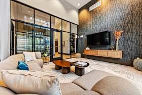 the lobby of a hotel with chairs and tables