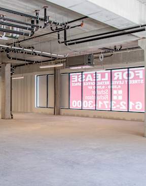 A large empty room with a red sign on the wall at The Redwell Apartments, Minnesota 55401