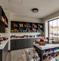 a store with a large window and a counter filled with bags and baskets of food at The Louis Apartment Flats, Louisville, KY