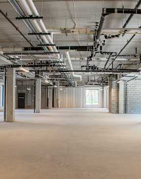 A large, empty industrial space with a high ceiling and multiple levels of ductwork at The Redwell Apartments, Minnesota