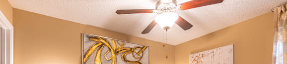 A bedroom with a bed, two lamps, and a ceiling fan. at Reserve of Bossier City Apartment Homes in Bossier City, LA 71111